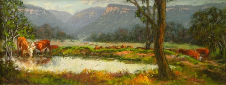 A landscape of cows drinking at a dam