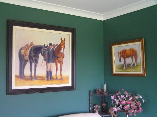 A large portrait of a rider with her two horses